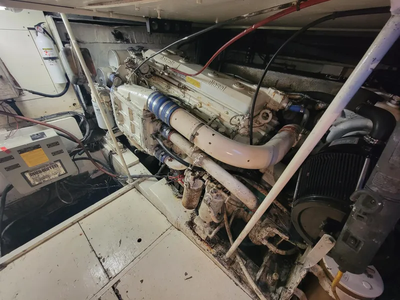 Slide: The Image of Engine room of a 1989 Trojan 46 Sportfish boat, showcasing mechanical components and wiring. - 28