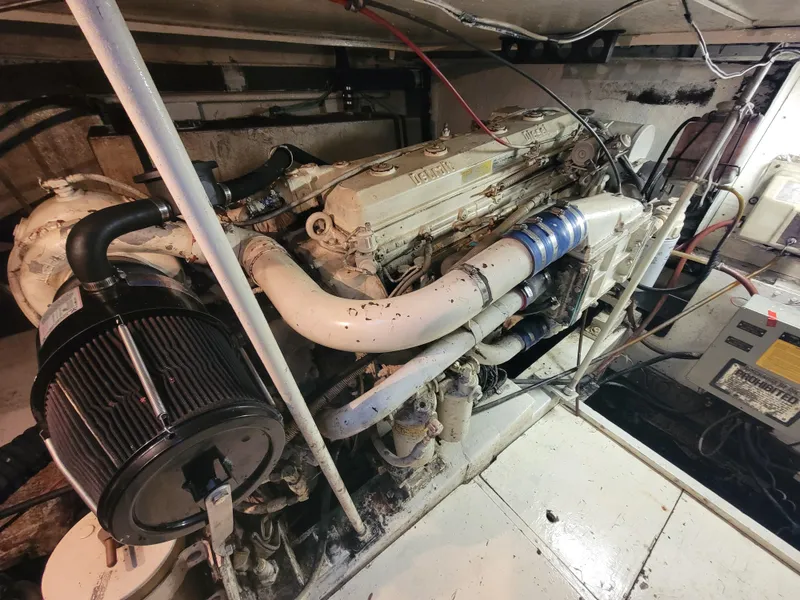 Slide: The Image of Engine room of a 1989 Trojan 46 Sportfish boat, showcasing mechanical components and wiring. - 29