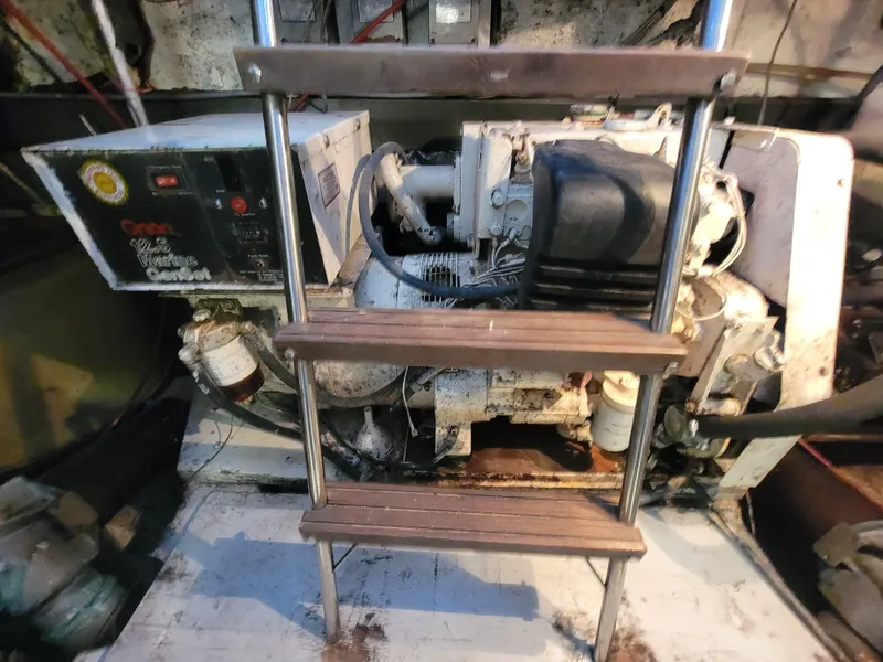 Slide: The Image of Engine room of a 1989 Trojan 46 Sportfish boat with visible machinery and ladder. - 30