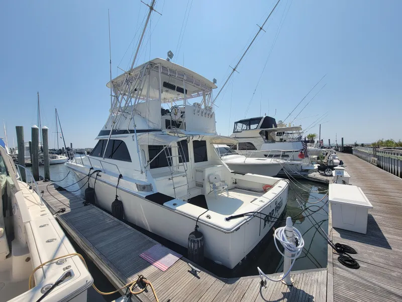Slide: The Image of 1989 Trojan 46 Sportfish yacht docked at marina under clear blue sky. - 4