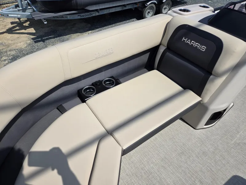 Slide: The Image of 2025 Harris Cruiser 210 boat interior with beige seating and cup holders. - 7
