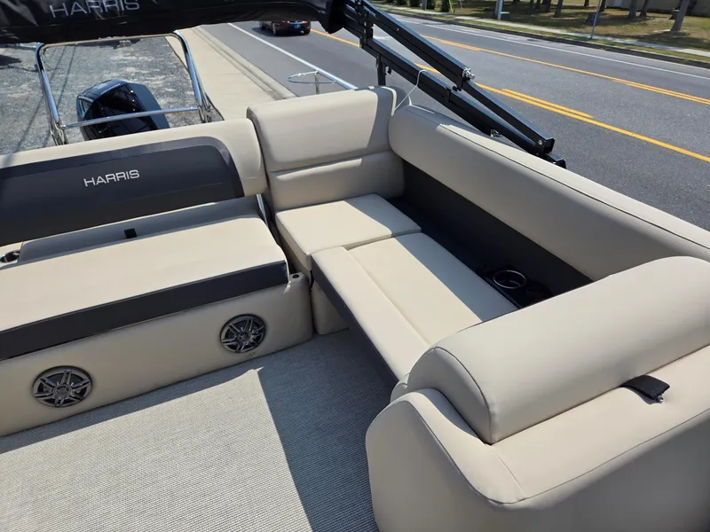 Slide: The Image of 2025 Harris Cruiser 210 boat interior with beige seating and speakers. - 9
