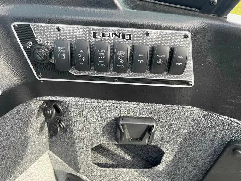 Slide: The Image of Control panel of 2025 Lund 1775 Impact XS Sport boat with various switches. - 18
