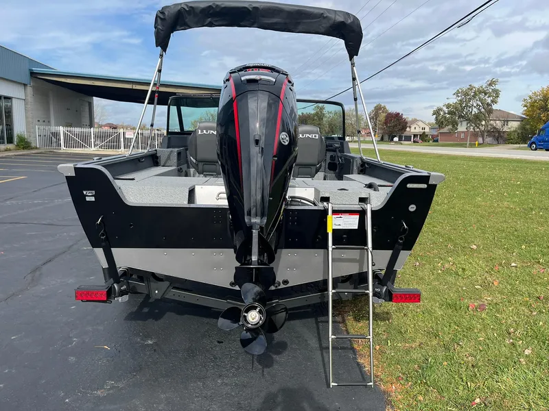 Slide: The Image of 2025 Lund 1775 Impact XS Sport boat, rear view with motor and ladder. - 2