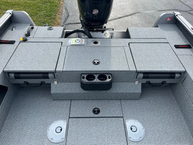 Slide: The Image of 2025 Lund 1775 Impact XS Sport boat interior with storage compartments and motor. - 7