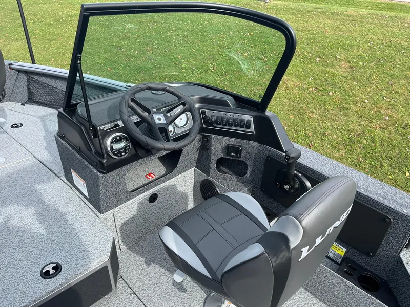 Slide: The Image of 2025 Lund 1775 Impact XS Sport boat interior with steering wheel and seat. - 9