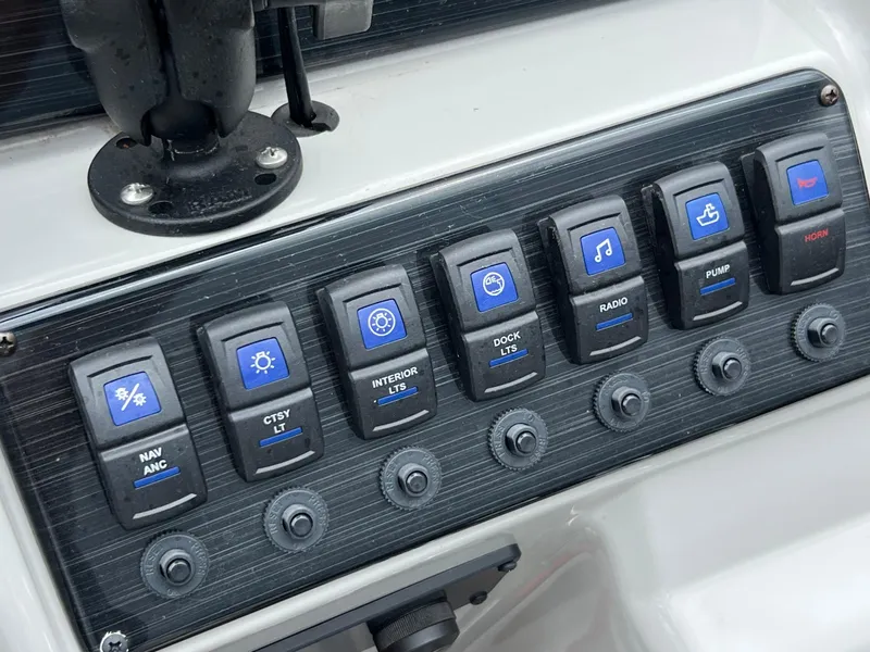 Slide: The Image of Control panel of 2023 Sylvan 8520 Party Fish boat with labeled switches. - 15