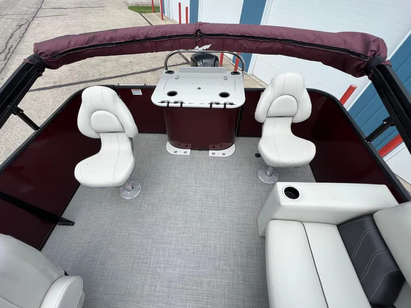Slide: The Image of 2023 Sylvan 8520 Party Fish boat interior with white seating and helm station. - 20