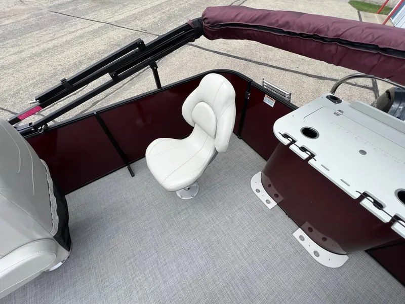 Slide: The Image of 2023 Sylvan 8520 Party Fish boat interior with white swivel chair and maroon accents. - 22