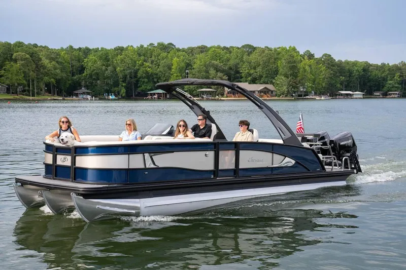 Slide: The Image of 2025 Barletta LUSSO 25UCAT pontoon boat cruising on a scenic lake. - 10