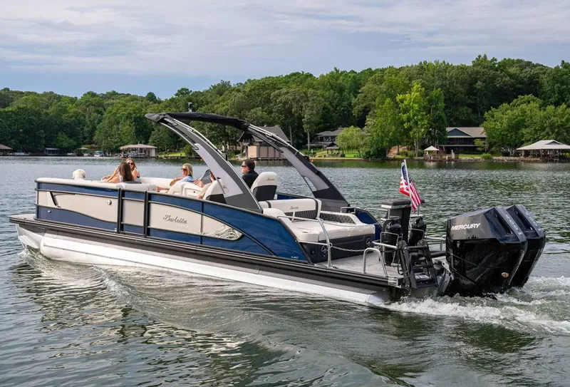 Slide: The Image of 2025 Barletta LUSSO 25UCAT pontoon boat cruising on a scenic lake. - 9