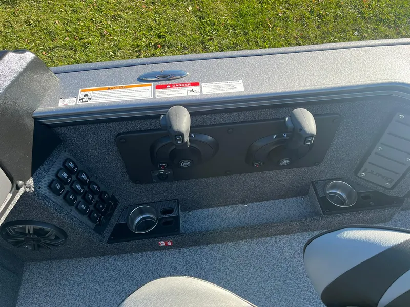Slide: The Image of 2025 Lund 1875 Pro-V boat console with controls and cup holders. - 10