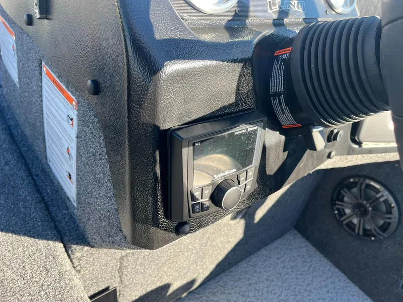 Slide: The Image of 2025 Lund 1875 Pro-V boat dashboard with control panel and speaker. - 12