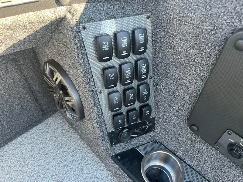 Slide: The Image of Control panel of 2025 Lund 1875 Pro-V boat with switches and speaker. - 13