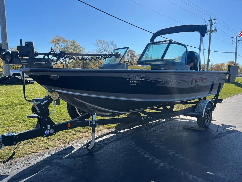 Slide: The Image of 2025 Lund 1875 Pro-V boat on trailer, parked outdoors on a sunny day. - 4