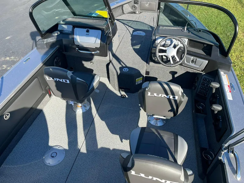 Slide: The Image of 2025 Lund 1875 Pro-V boat interior with steering wheel and seating. - 8