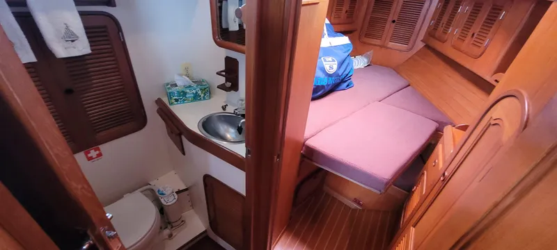 Slide: The Image of 1985 Mason 33 Sloop interior with compact bathroom and cozy sleeping area. - 10