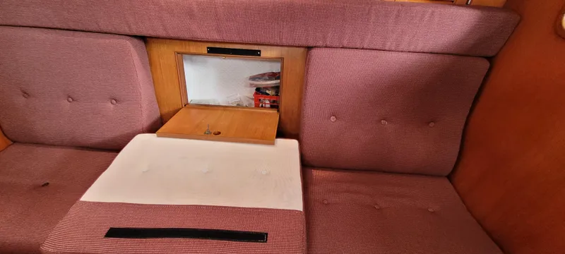 Slide: The Image of Interior cabin of 1985 Mason 33 Sloop with red checkered upholstery and storage compartment. - 13