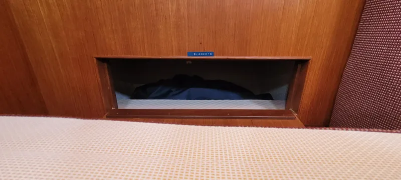Slide: The Image of Interior view of a 1985 Mason 33 Sloop sailboat with wooden paneling. - 15