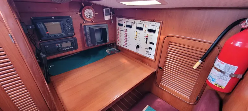 Slide: The Image of Navigation station inside 1985 Mason 33 Sloop with control panels and equipment. - 16