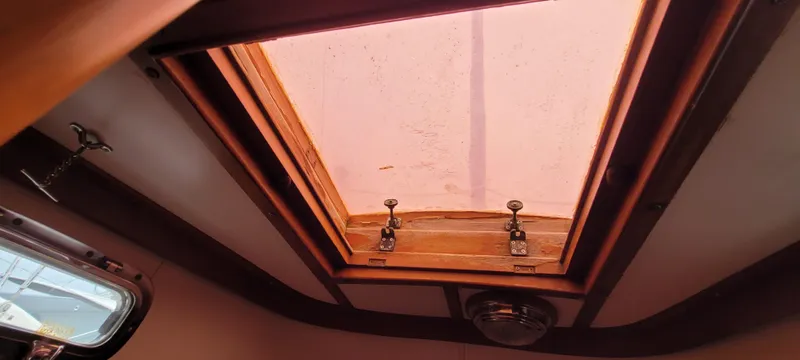 Slide: The Image of Interior view of a 1985 Mason 33 Sloop's skylight with wooden frame and latches. - 19