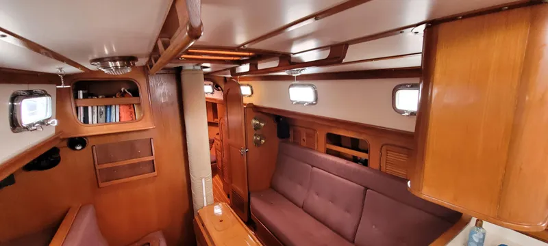 Slide: The Image of Interior of 1985 Mason 33 Sloop sailboat with wooden furnishings and cozy seating. - 2
