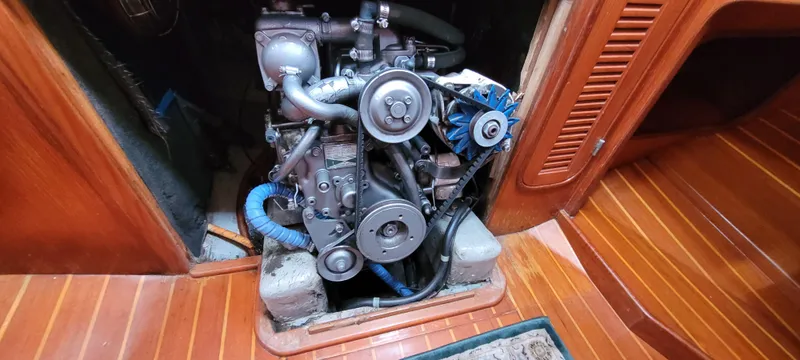 Slide: The Image of Engine compartment of a 1985 Mason 33 Sloop, showcasing mechanical components and wooden interior. - 28