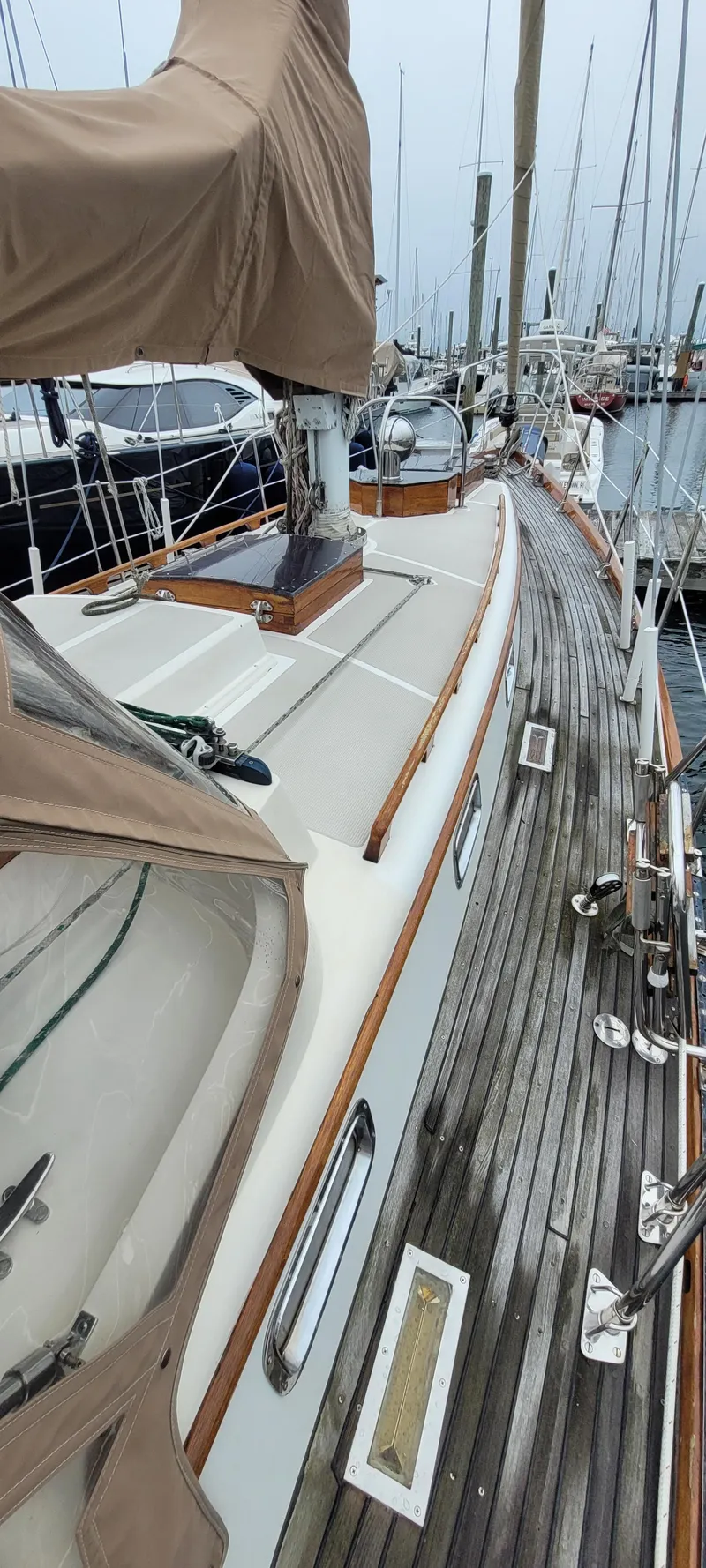 Slide: The Image of 1985 Mason 33 Sloop sailboat docked, featuring teak deck and covered mast. - 31