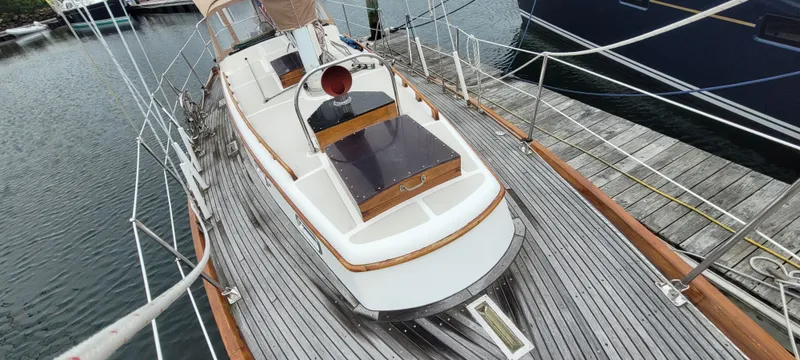 Slide: The Image of 1985 Mason 33 Sloop docked, showcasing wooden deck and sleek design. - 33