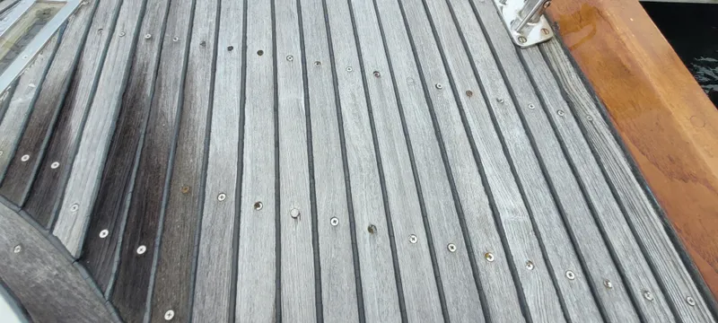 Slide: The Image of Teak deck of 1985 Mason 33 Sloop sailboat, featuring wood grain and metal fasteners. - 37