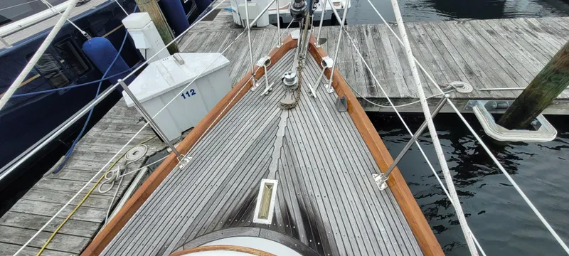 Slide: The Image of 1985 Mason 33 Sloop docked, showcasing wooden deck and rigging. - 39