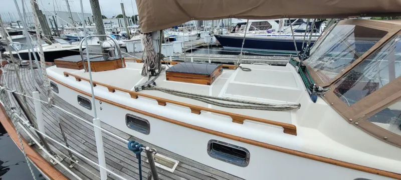 Slide: The Image of 1985 Mason 33 Sloop sailboat docked in marina, featuring wooden deck and cabin details. - 41