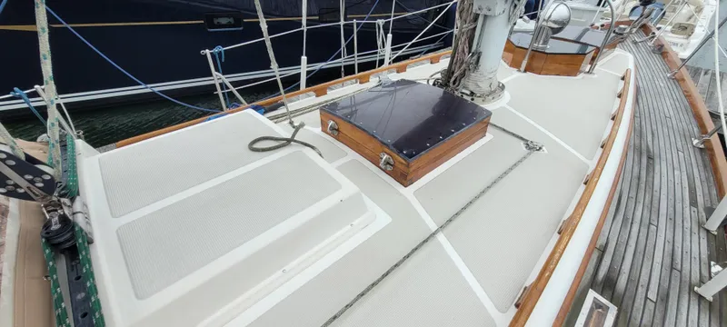 Slide: The Image of 1985 Mason 33 Sloop deck with rigging and wooden accents, docked at marina. - 44