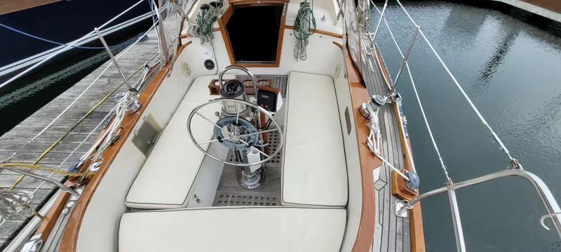 Slide: The Image of Cockpit of 1985 Mason 33 Sloop with steering wheel and cushioned seating. - 47