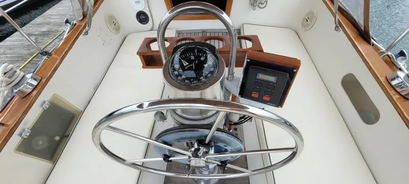 Slide: The Image of Cockpit of 1985 Mason 33 Sloop with steering wheel, compass, and navigation instruments. - 49