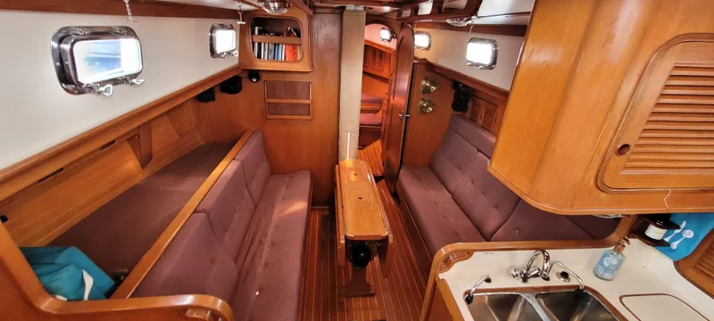 Slide: The Image of Interior of 1985 Mason 33 Sloop sailboat with cozy seating and wooden finishes. - 5