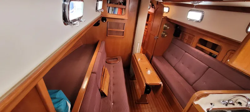 Slide: The Image of Interior of 1985 Mason 33 Sloop sailboat with wooden furnishings and cozy seating. - 7