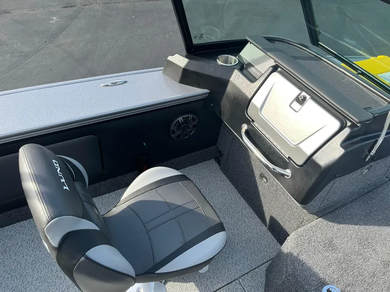 Slide: The Image of 2025 Lund 1875 Pro-V boat interior with black and gray seating and dashboard. - 17