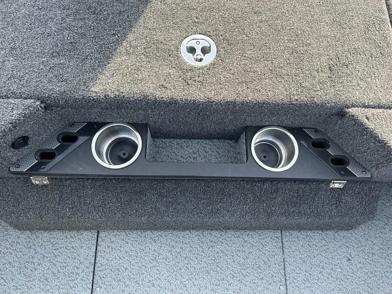 Slide: The Image of 2025 Lund 1875 Pro-V boat interior with cup holders and carpeted flooring. - 23