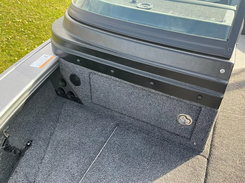 Slide: The Image of 2025 Lund 1875 Pro-V boat interior with gray carpet and storage compartment. - 27