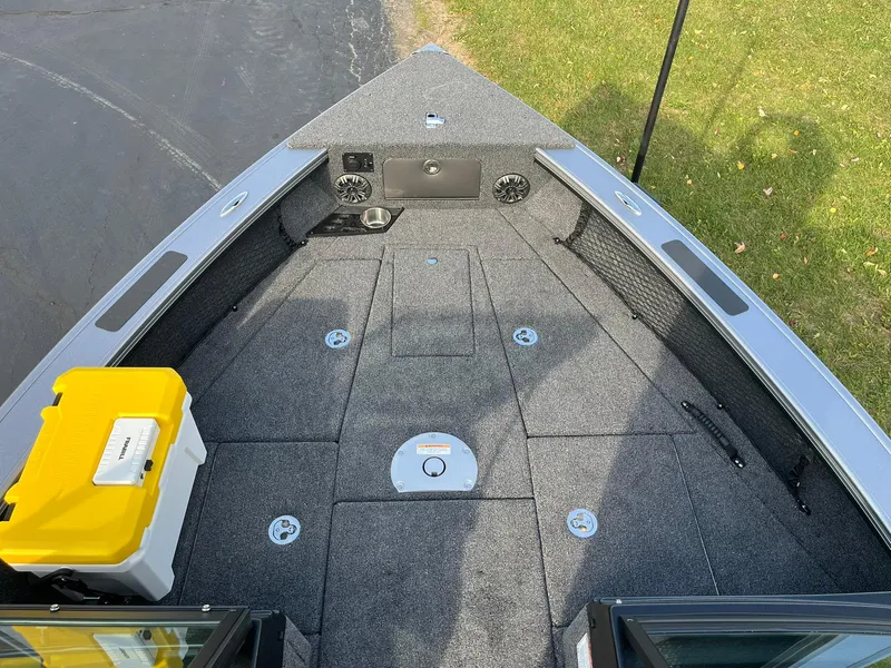 Slide: The Image of 2025 Lund 1875 Pro-V boat deck with storage compartments and a yellow cooler. - 9