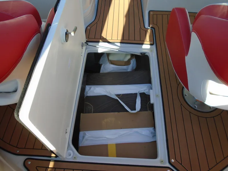Slide: The Image of 2024 Crownline Eclipse E255 SURF boat storage compartment with teak flooring and red seats. - 14