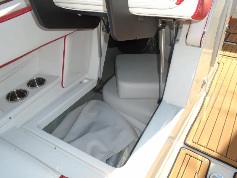 Slide: The Image of 2024 Crownline Eclipse E255 SURF boat interior storage compartment with cup holders and cushioned seating. - 18