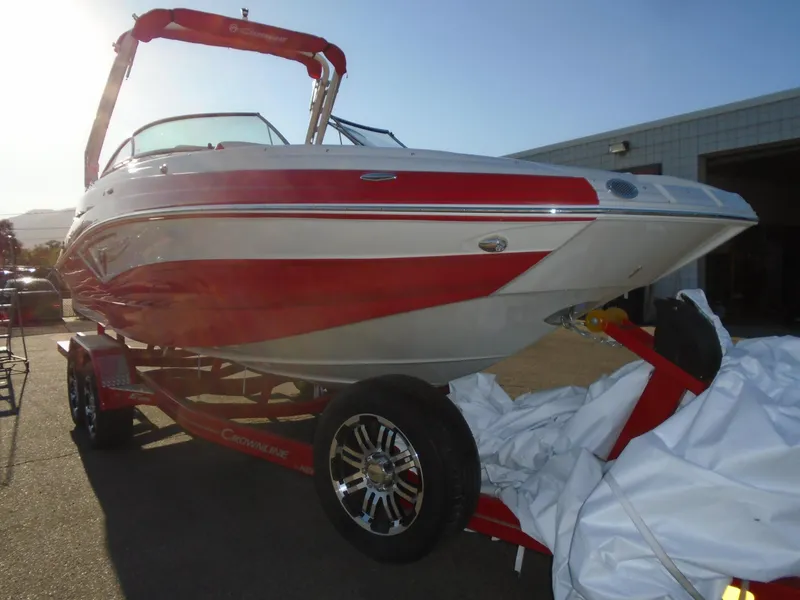 Slide: The Image of 2024 Crownline Eclipse E255 SURF boat with red and white design on trailer. - 4