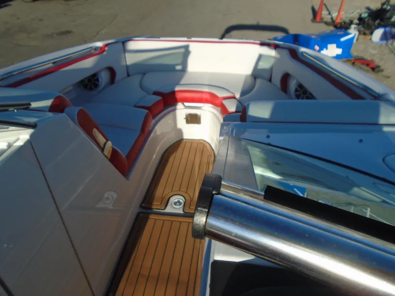 Slide: The Image of 2024 Crownline Eclipse E255 SURF boat interior with red and white seating, wooden flooring. - 5