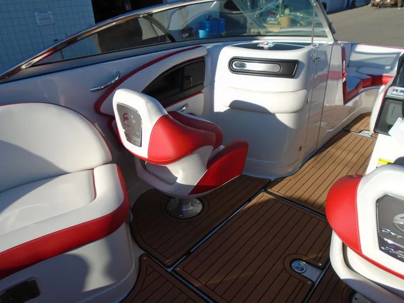 Slide: The Image of 2024 Crownline Eclipse E255 SURF boat interior with red and white seating, wood flooring. - 8