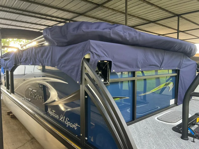 Slide: The Image of 2025 JC 21 NEPTOON TT Sport boat with blue cover in a sheltered area. - 4