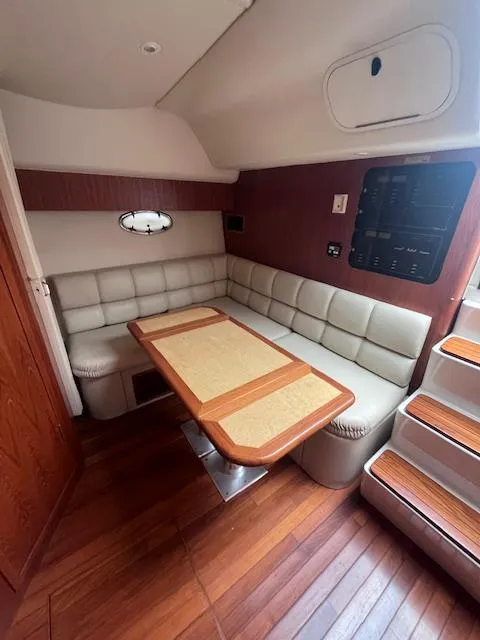 Slide: The Image of 2001 Tiara Yachts 3500 Express interior with wood flooring and cushioned seating. - 10
