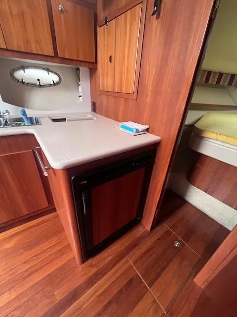 Slide: The Image of 2001 Tiara Yachts 3500 Express interior with wood cabinetry and compact kitchen area. - 12