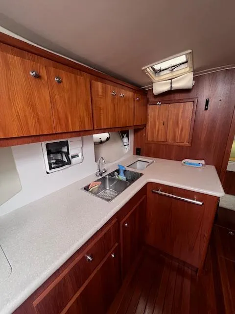 Slide: The Image of 2001 Tiara Yachts 3500 Express kitchen with wooden cabinets and modern sink. - 13
